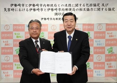 協定書を手にする伊勢崎郵便局長と五十嵐市長の写真