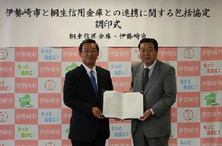 協定書を手にする桐生信用金庫理事長と五十嵐市長の写真