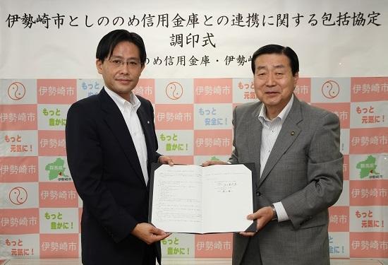 協定書を手にするしののめ信用金庫理事長と五十嵐市長の写真