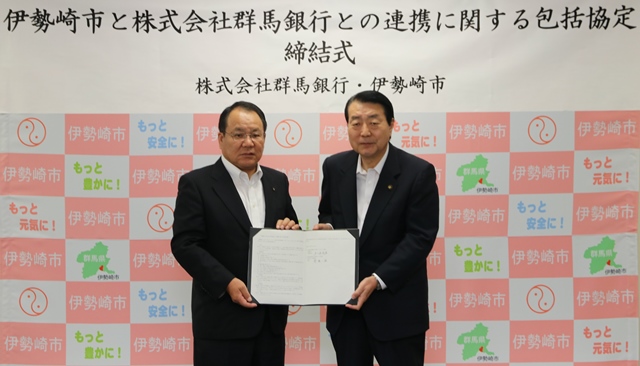 協定書を手にする株式会社群馬銀行頭取と五十嵐市長の写真
