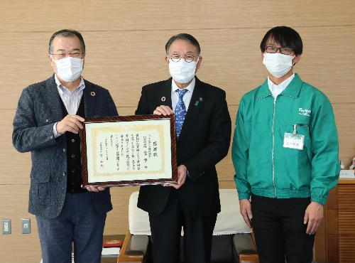 感謝状を掲げる臂市長とファームドゥグループ岩井雅之代表