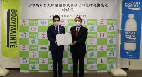 協定書を手にする大塚製薬株式会社大宮支店長及び臂市長の写真