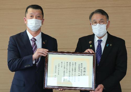 感謝状を掲げる臂市長と株式会社中西製作所の山中群馬工場長