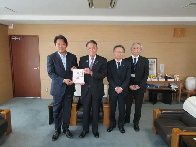 寄附贈呈式で目録を手にする市長