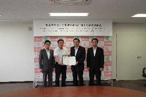 災害対策室で群馬県宅地建物取引業協会3人と五十嵐市長が協定書を携えている写真