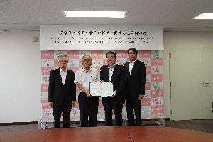 災害対策室で伊勢崎土木建築業協同組合3人と五十嵐市長が協定書を携えている写真