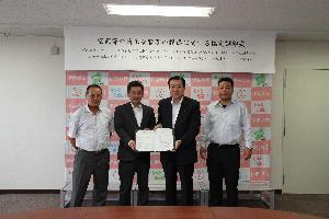 災害対策室で伊勢崎造園事業協同組合3人と五十嵐市長が協定書を携えている写真