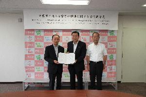 災害対策室で伊勢崎市シルバー人材センター2人と五十嵐市長が協定書を携えている写真