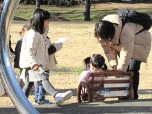 公園内の数か所のポイントの問題に答え、スタンプを集めてスタンプラリーを楽しむ親子の写真