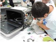 壊れた家電を分解している子供の写真