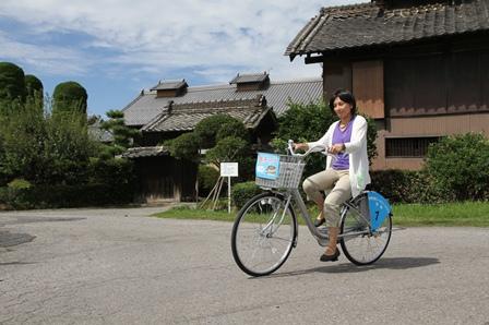 レンタサイクル島チャリを利用する女性の写真