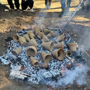 炭の中にくべられた焼成前の縄文土器