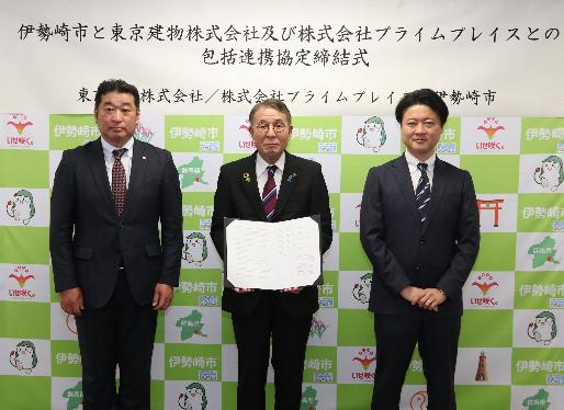 協定書を手にする臂市長(真ん中)及び東京建物株式会社商業事業部長(左)、株式会社プライムプレイススマークオペレーションセンター長(右)の写真