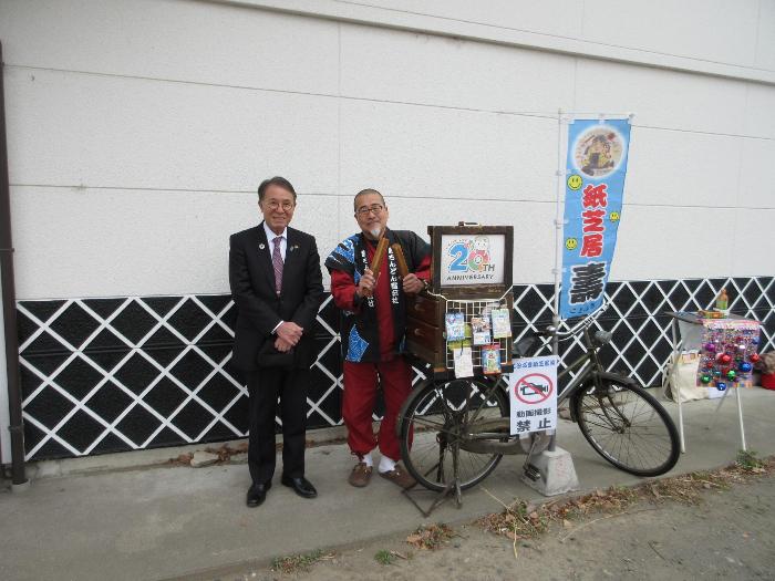 紙芝居口演を行っている石原之壽さんと写真に写る市長