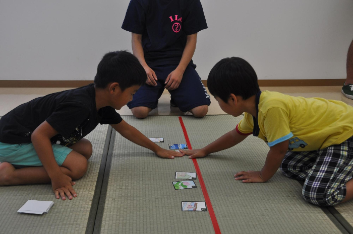 二人の男の子がかるた取りをしている写真