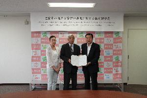 災害対策室で全日本不動産協会群馬県本部2人と五十嵐市長が協定書を携えている写真