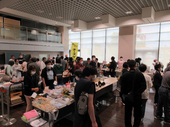 いせさき福祉ふれあいマルシェの会場で何を買うか出店をのぞいている来場者たち