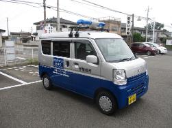 安心安全パトロール車の写真。ワンボックス型の軽自動車の屋根に青色の回転灯が取り付けられています