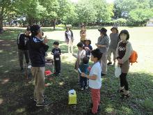 先生と一緒に公園を回って自然についてのレクチャーを受けている写真