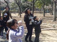まゆドームの公園内で、双眼鏡を使って鳥を観察している子供たちの写真