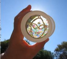 2枚の偏光板の間に、ウルトラマンの絵を描いた透明シートを挟んで、光を通してみた写真