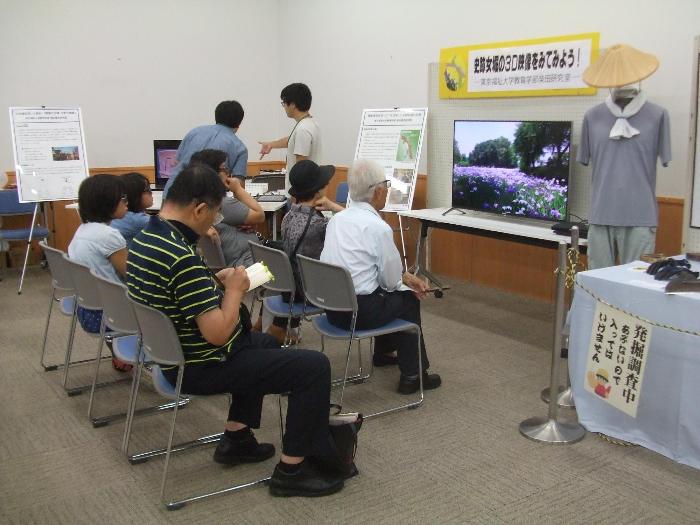 埋蔵文化財展開催時に、来場者が椅子に座って史跡女堀の3D映像を見ている様子の写真